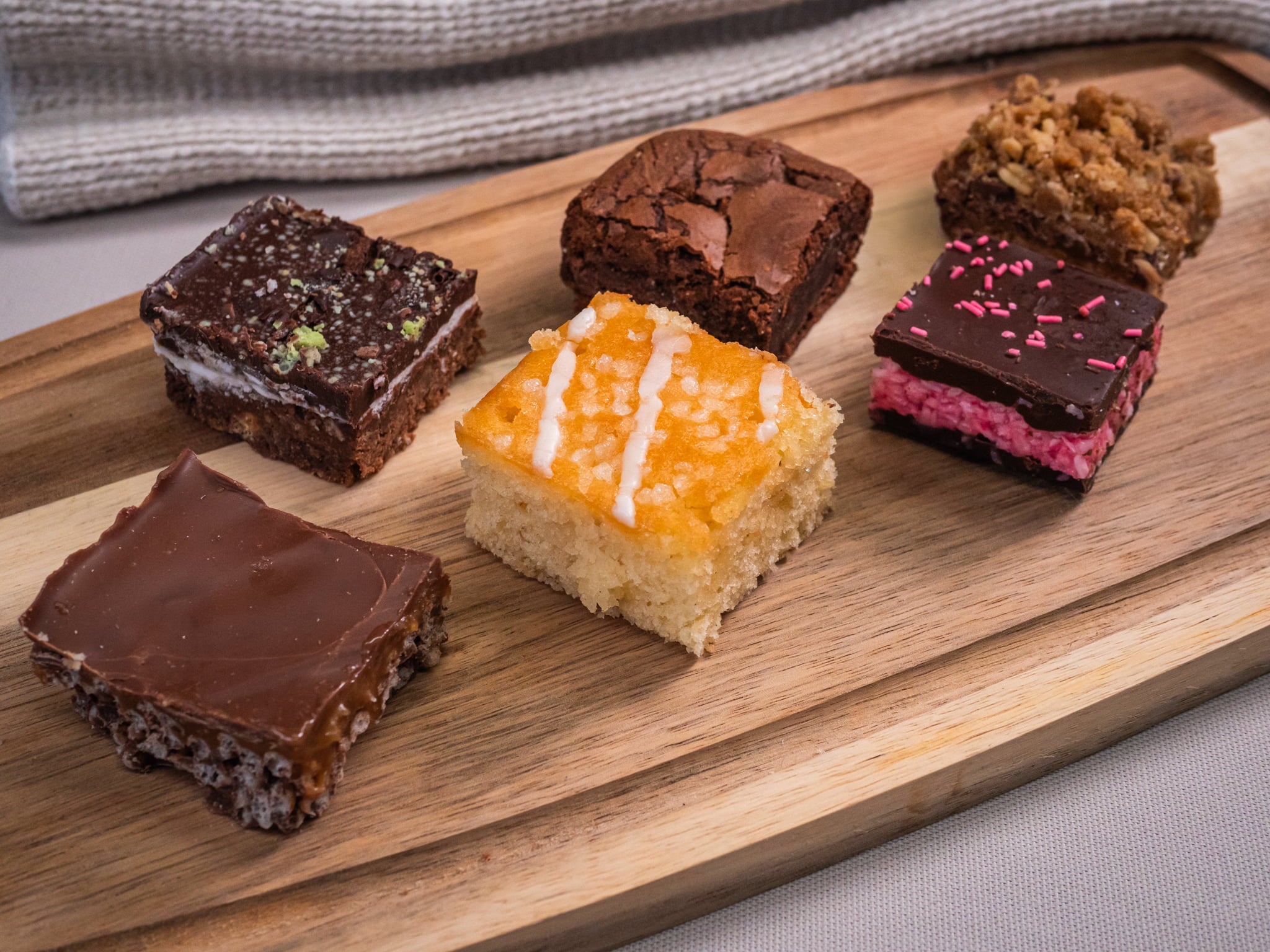 The Sub Side Assorted TrayBake Box features 24 pieces of house favorites like chocolate brownie bars and layered dessert squares, beautifully arranged for the perfect dessert platter.