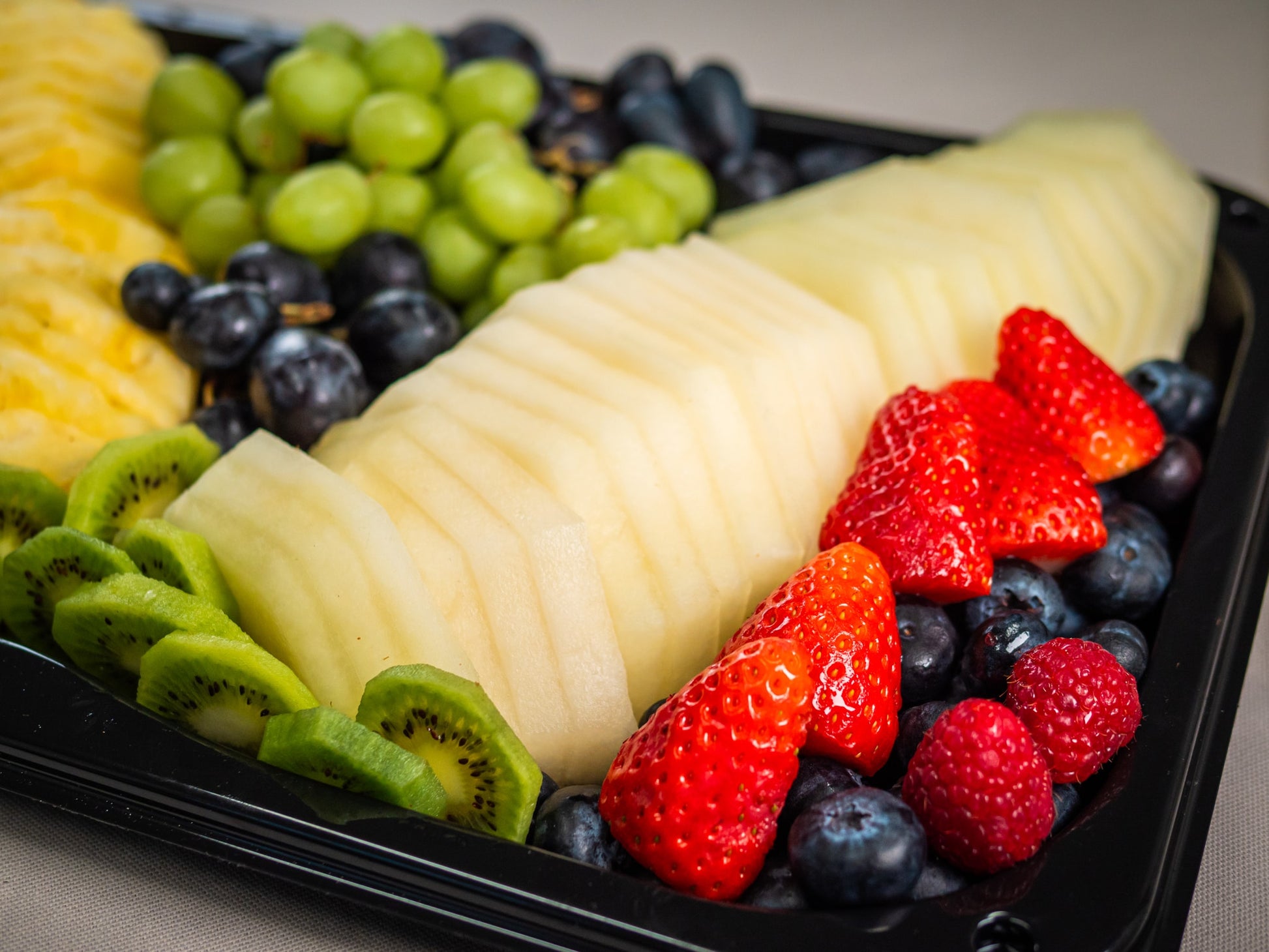 The Sub Side Fresh Fruit Medley (serves 12/24) features carved melon, seasonal berries, pineapple, kiwi, and mixed grapes all beautifully arranged on a platter.