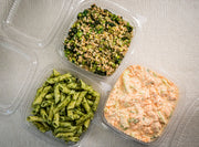 Sub Side's Trio of Salads (3 x 500g) features Nut Free Pesto Pasta, Green Wheat Salad with vegetables, and creamy Hot Honey Slaw in clear containers, all arranged on a light textured surface.